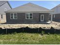 Brick home featuring a covered patio and a level yard at 1366 Foxtail Ln, Greenwood, IN 46143