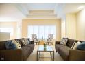 Bright living room featuring two couches, plush pillows, modern decor, and a tray ceiling at 1502 Heron Ridge Blvd, Greenwood, IN 46143