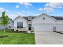 Beautiful home featuring a two-car garage, lush green lawn, stone accents, and a welcoming front door at 1627 Clover Crossing Dr, Greenfield, IN 46140