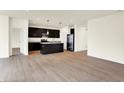 Open floor plan showcases the modern kitchen with island and dark cabinets, flowing into the living area at 1627 Clover Crossing Dr, Greenfield, IN 46140