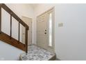 Bright foyer featuring tile flooring, staircase, and front door with sidelight at 2619 Chaseway Ct, Indianapolis, IN 46268
