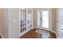 Welcoming foyer with hardwood floors, decorative glass front door, and adjacent french doors at 2838 Violet W Ct, Columbus, IN 47201