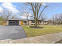 Charming single-story home with stone facade, updated black trim, and an inviting orange front door at 2951 E 62Nd St, Indianapolis, IN 46220