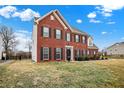 Charming two-story brick home with black shutters and manicured landscaping, set against a blue sky at 3236 Springs Way Dr, Bargersville, IN 46106