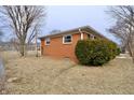 A brick home's exterior, featuring a fenced yard and mature trees at 3422 Ferncliff Ave, Indianapolis, IN 46227