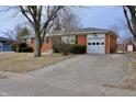 A single story brick home featuring an attached garage and a concrete driveway at 3422 Ferncliff Ave, Indianapolis, IN 46227