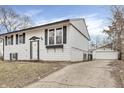 Charming two-story home with a white exterior, black shutters, and a detached one car garage at 4249 Dubarry Rd, Indianapolis, IN 46226