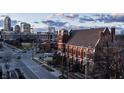 An aerial view of a brick church with a view of downtown buildings under a cloudy sky on a sunny day at 501 Fletcher Ave # D, Indianapolis, IN 46203