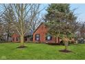 Lovely brick home with a lush green lawn and mature trees at 605 Sugarbush Dr, Zionsville, IN 46077