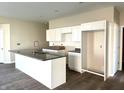 Kitchen featuring a large island with granite countertop, white cabinets, and stainless steel faucet at 614 Silver Fox Ct, Indianapolis, IN 46217