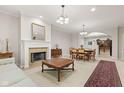 A spacious living room with a fireplace, classic furniture, and an open dining area at 6691 Beekman Pl, Zionsville, IN 46077
