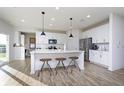 Bright, open kitchen features white cabinetry, stainless steel appliances, and a large center island with bar seating at 7156 Firestone Rd, Whitestown, IN 46052