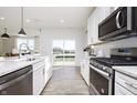 Close-up view of a well-appointed kitchen with stainless steel appliances and sliding glass doors to the backyard at 7156 Firestone Rd, Whitestown, IN 46052