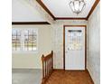 Inviting entryway featuring classic wood trim, decorative wallpaper and a beautiful, decorative front door at 725 Queenswood Dr, Indianapolis, IN 46217