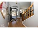 Inviting foyer with hardwood floors and a staircase, offering a view into the adjacent living area at 7822 Ashton Ln, Fishers, IN 46038
