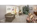 Cozy living room with large window, neutral carpet, comfortable seating, and a built-in bookshelf at 7822 Ashton Ln, Fishers, IN 46038
