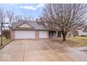 Charming brick home featuring a three-car garage and spacious driveway at 8333 Hunters Meadow Ct, Indianapolis, IN 46259