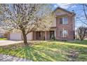 Charming home featuring a well-manicured lawn, mature tree and a welcoming two-car garage at 8333 Hunters Meadow Ct, Indianapolis, IN 46259