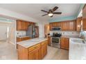 Well-lit kitchen with stainless steel appliances, island, wooden cabinets, and vinyl floors at 1023 N Quiet Bay Cir, Cicero, IN 46034