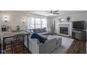 Comfortable living room with a fireplace, ceiling fan, large sofa, and dining area at 10920 Gate Cir, Fishers, IN 46038