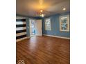 Bright living room with wood floors and light blue walls, offering ample space and a warm ambiance at 1425 W 9Th St, Anderson, IN 46016