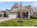 Attractive home with a two-car garage, lush green lawn, and stone-accented pillars on the covered porch at 16771 Cattle Hollow Ln, Noblesville, IN 46060