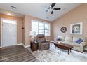 Bright living room boasts new wood flooring, a ceiling fan, large windows, and comfortable seating at 18357 Piers End Dr, Noblesville, IN 46062