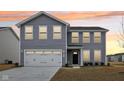 Charming two-story home with gray siding, a two-car garage, and manicured front yard at sunset at 1854 Cascades Dr, Greenfield, IN 46140