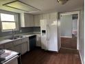 Functional kitchen featuring white cabinets, laminate countertops, and a refrigerator at 2346 Mayfair Dr, Indianapolis, IN 46260