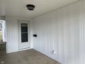 Inviting front porch with white paneling, a classic light fixture, and convenient electrical outlet at 2712 S A St, Elwood, IN 46036