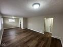 Spacious living room with new dark wood flooring, neutral walls, and ample natural light at 3851 N Campbell Ave, Indianapolis, IN 46226