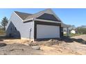 A side view of a new construction with an attached garage and light blue siding in a rural environment at 3885 Berkdale Ct, Columbus, IN 47203