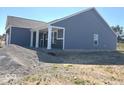 Image of the rear of a new construction with blue siding and a covered porch. Lot is still under construction at 3885 Berkdale Ct, Columbus, IN 47203