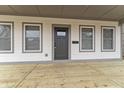 Covered front porch featuring a gray front door, wood decking, and white trim at 4054 Boulevard Pl, Indianapolis, IN 46208