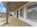 Welcoming front porch with wood decking, gray support posts, and recessed lighting at 4054 Boulevard Pl, Indianapolis, IN 46208