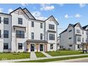 Newly built white townhome with black trim and welcoming front entrances framed by wooden posts at 4180 Douro Trl, Westfield, IN 46062