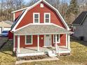 Charming two-story home with red siding, white trim, and a cozy covered front porch at 5334 E Burgess Ave, Indianapolis, IN 46219