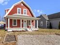 Charming two-story home with red siding, white trim, and a cozy covered front porch at 5334 E Burgess Ave, Indianapolis, IN 46219