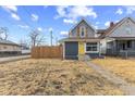 Charming exterior with a yellow front door and a partially fenced front yard at 714 S Keystone Ave, Indianapolis, IN 46203