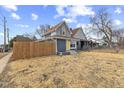 Cozy two-story home with a bright yellow front door and a wooden fence at 714 S Keystone Ave, Indianapolis, IN 46203