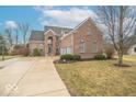 Beautiful brick home featuring an attached two-car garage and inviting driveway with a basketball hoop at 7823 Beechwood Farms Dr, Avon, IN 46123