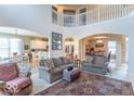 Bright living room with soaring ceilings, archways, comfortable furnishings, and seamless flow to dining and kitchen areas at 7823 Beechwood Farms Dr, Avon, IN 46123