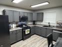 Modern kitchen boasts gray cabinetry, stainless steel appliances, and stylish wood-look flooring at 785 Country Gate Dr, New Whiteland, IN 46184