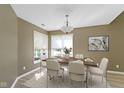 Cozy dining room featuring a wooden table, six chairs, a chandelier, and a bright window at 8212 Nekton Ln, Indianapolis, IN 46236