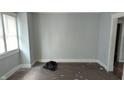 A minimalist bedroom with light gray walls, hardwood floors, and a bright window at 951 N Tuxedo St, Indianapolis, IN 46201