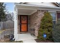 Inviting entryway featuring a brick facade, an orange front door, and neat landscaping at 10154 Holly Berry Cir, Fishers, IN 46038