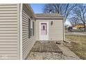 Home exterior featuring a cute pink door, siding, and small porch with stone detailing at 103 S Delawanda Ave, Muncie, IN 47303
