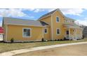 Stylish two-story home featuring yellow siding, well-kept landscaping, and a concrete walkway at 10483 St Anne Dr, Zionsville, IN 46077