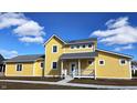 Bright yellow two-story home with a quaint front porch, complemented by a clear blue sky at 10483 St Anne Dr, Zionsville, IN 46077