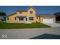 Beautiful yellow two-story home with a two-car garage and well-kept lawn at 10483 St Anne Dr, Zionsville, IN 46077